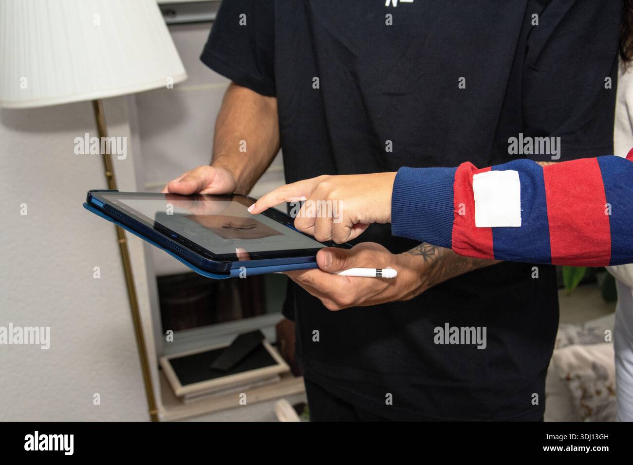 Two people collaborating on digital tablet using stylus Stock Photo