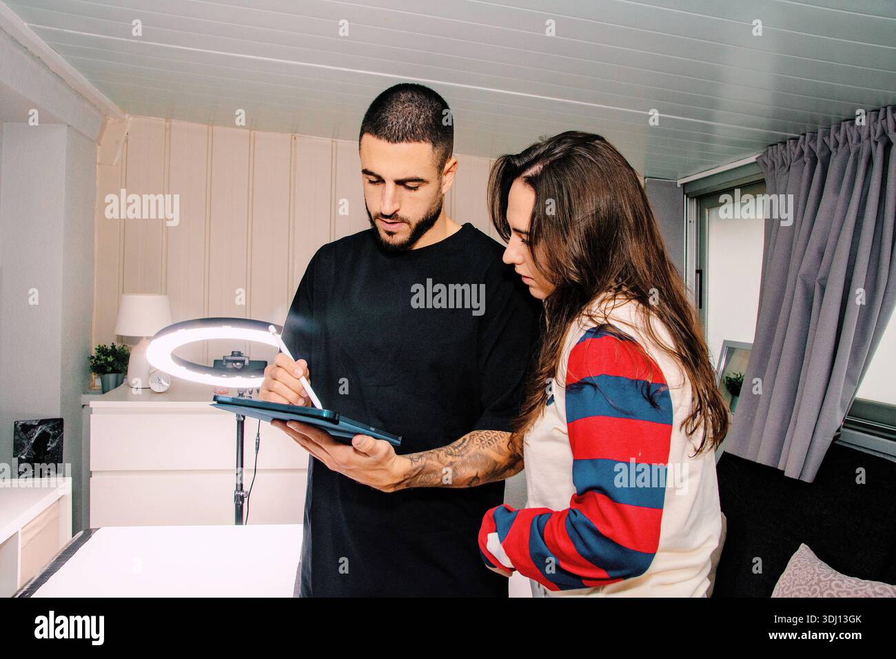 Creative team collaborating on digital design using tablet and stylus Stock Photo