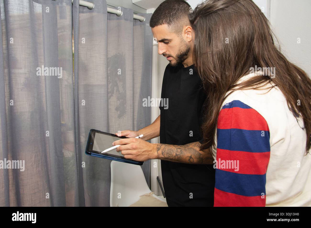 People collaborating on digital tablet using stylus Stock Photo