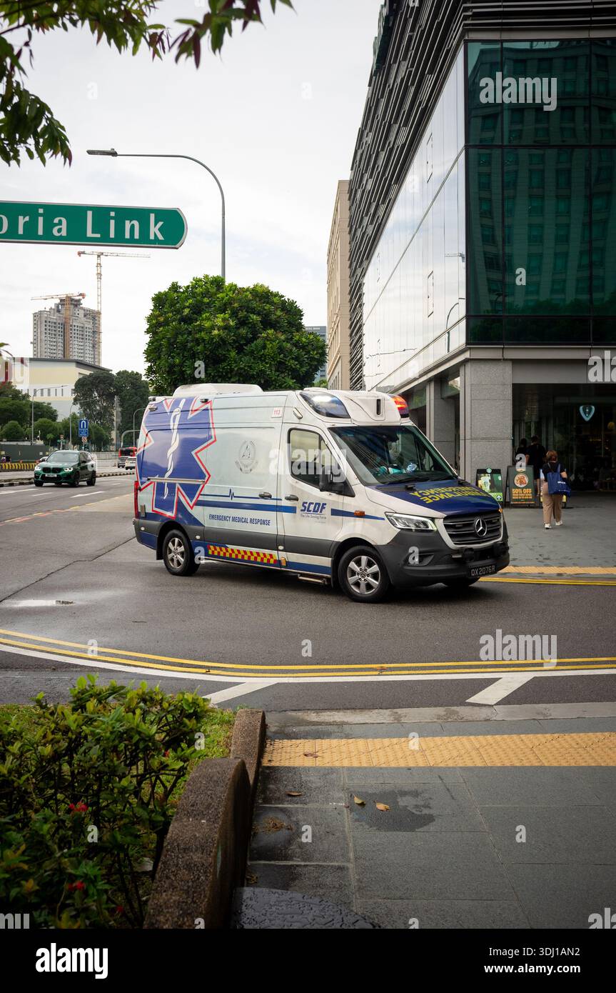 An Emergency ambulance vehicle arrives with sirens and flashing lights at Raffles Hosptal Singapore Asia. Stock Photo