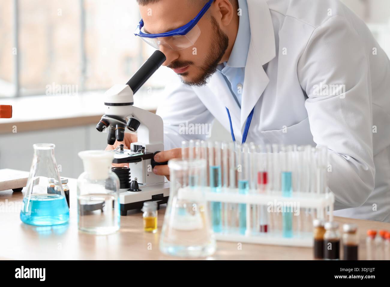 Male scientist looking through microscope in laboratory Stock Photo