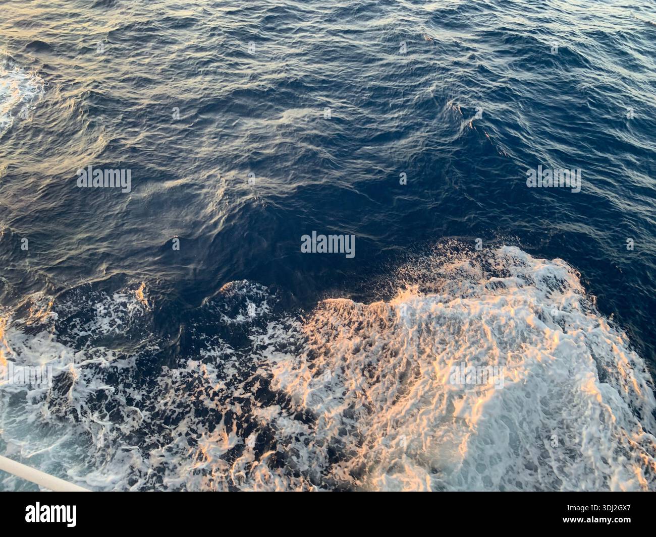 Deep Blue Ocean Waves and White Sea Foam Created by Boat Wake at Golden Hour - Smartphone Captured Stock Image