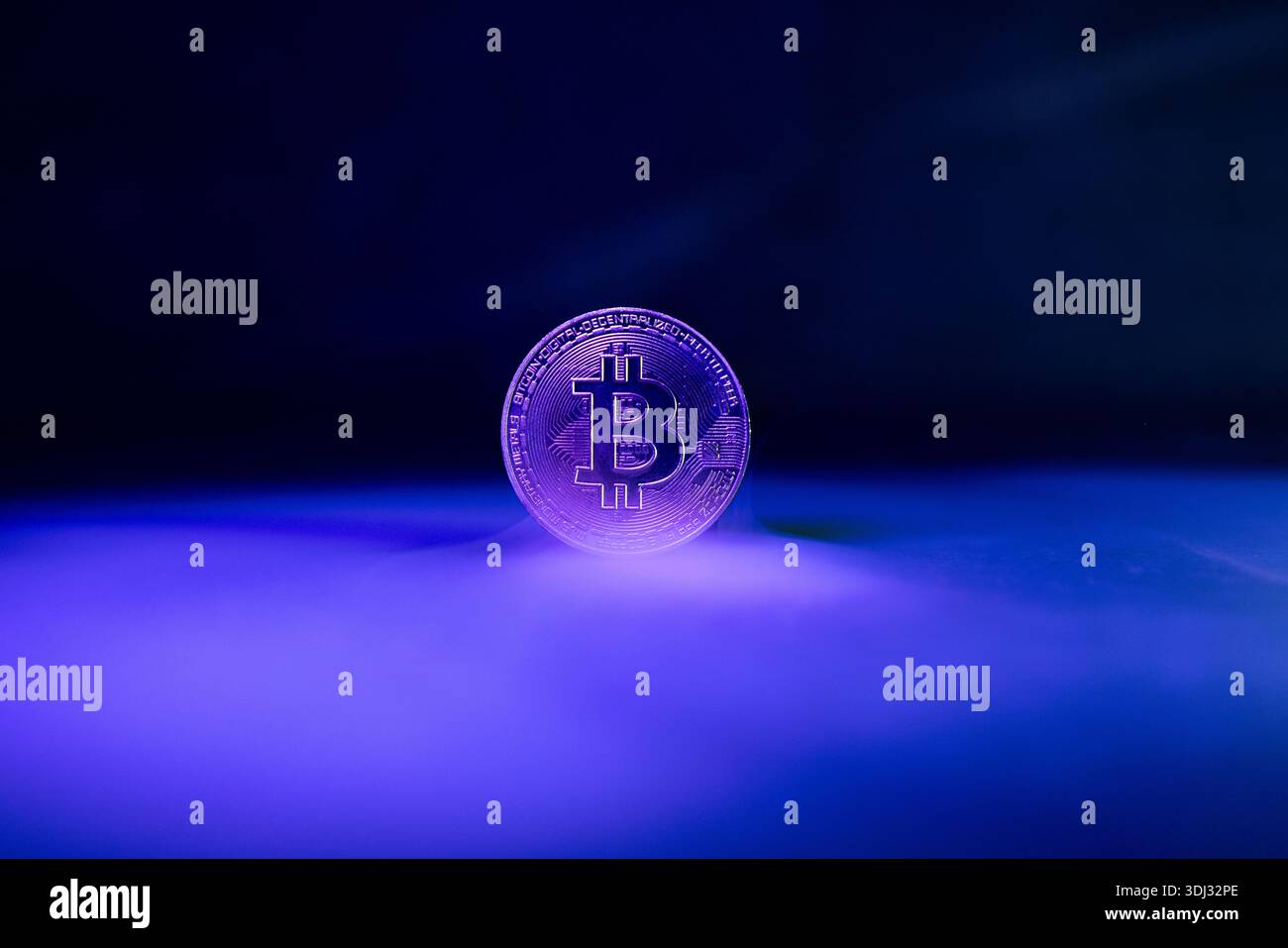 Bitcoin with Golden Glow Reflected on Surface Stock Photo