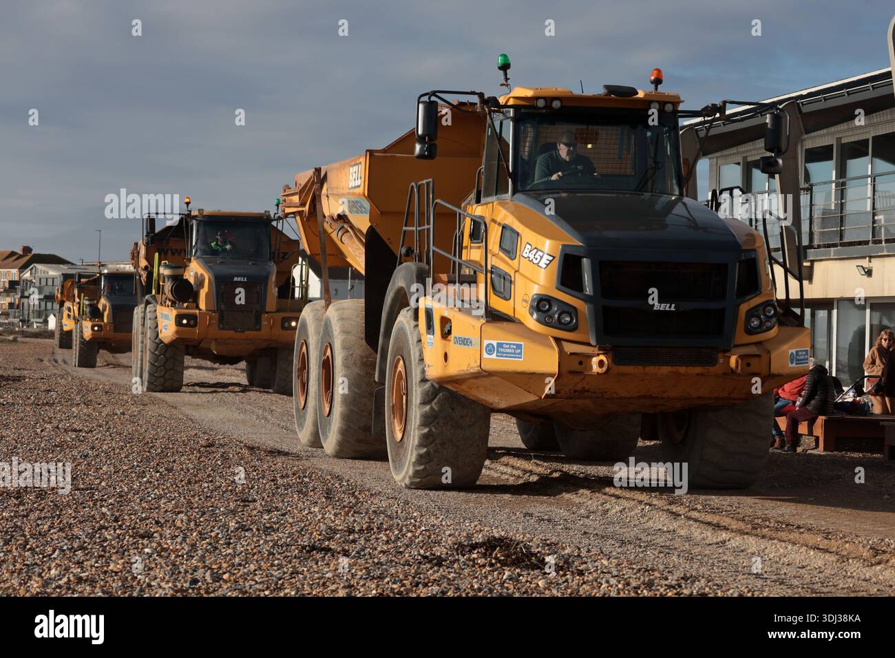 A fleet of Bell B45E dump trucks carrying shingle to strengthen sea ...