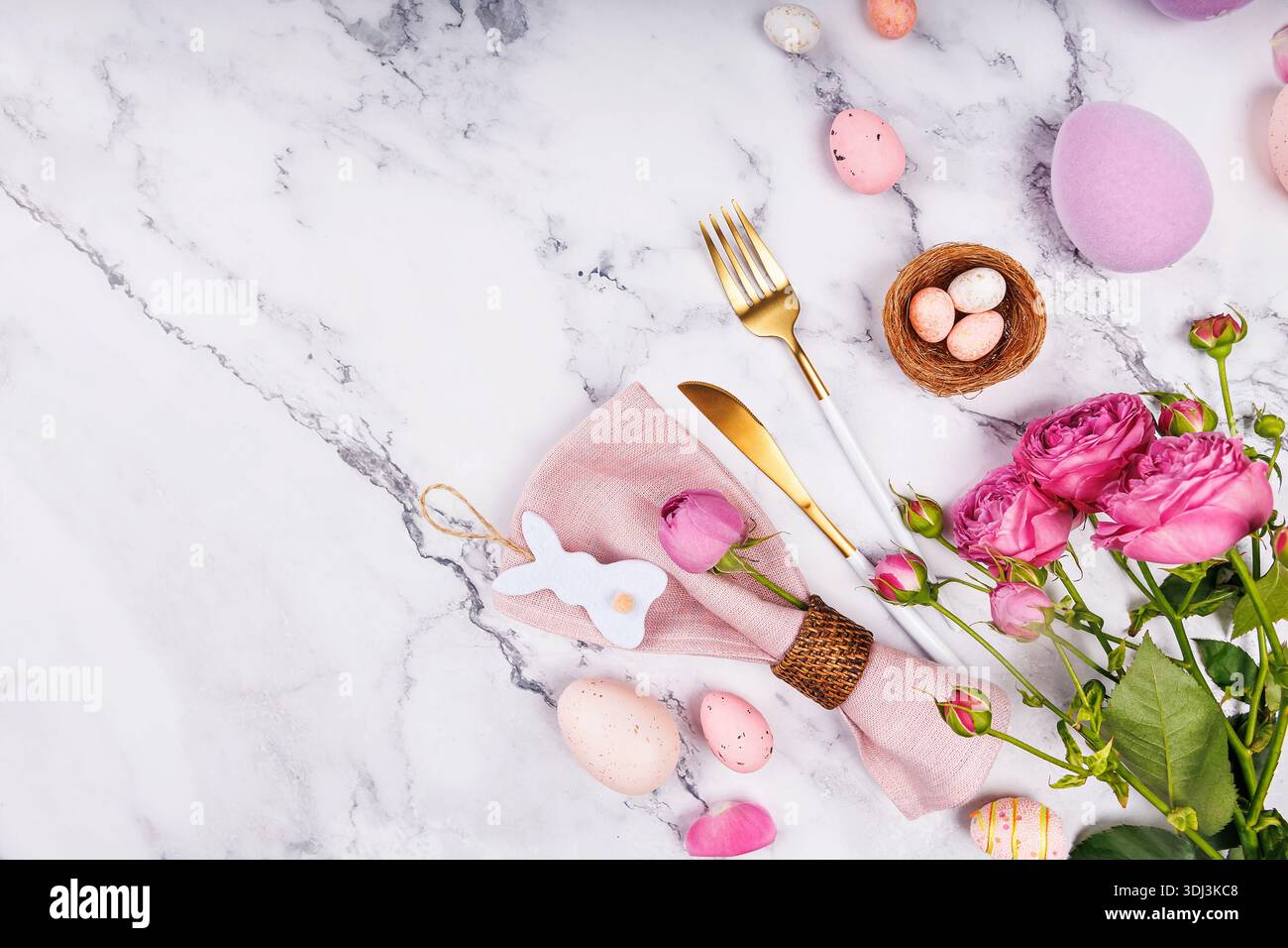 Easter Table Setting with Roses and Gold Cutlery Stock Photo