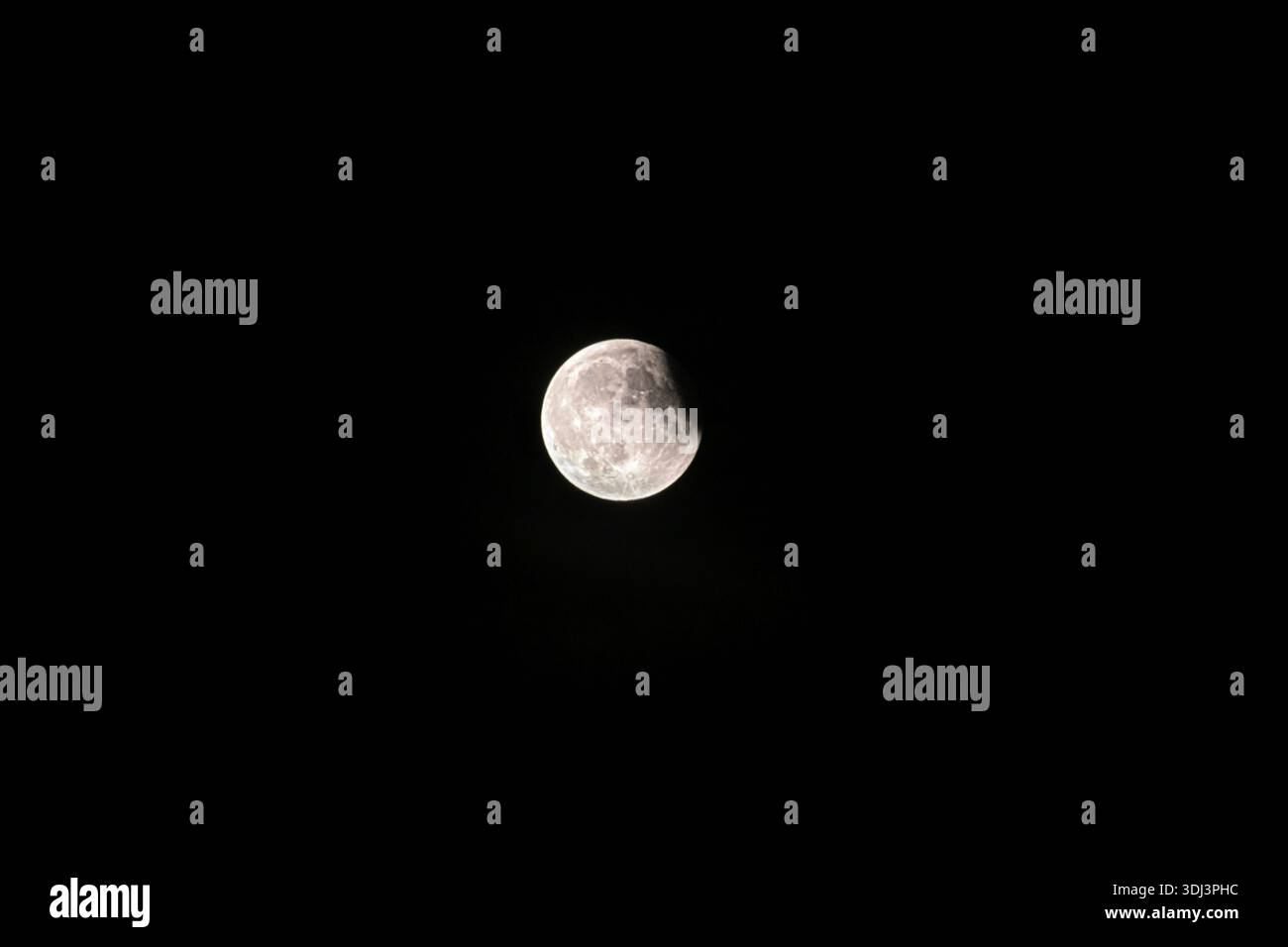 A half-moon brightly illuminated against a dark night sky, eclipse, Italy Stock Photo