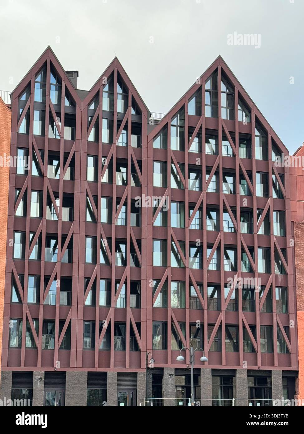 Modern office building with a geometric facade and repetitive structural pattern, showcasing contemporary European architecture and urban design - Smartphone Captured Stock Image