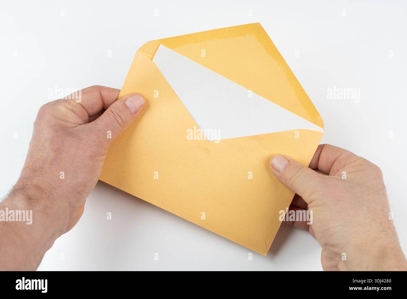 an open yellow envelope in the hands on a white surface Stock Photo