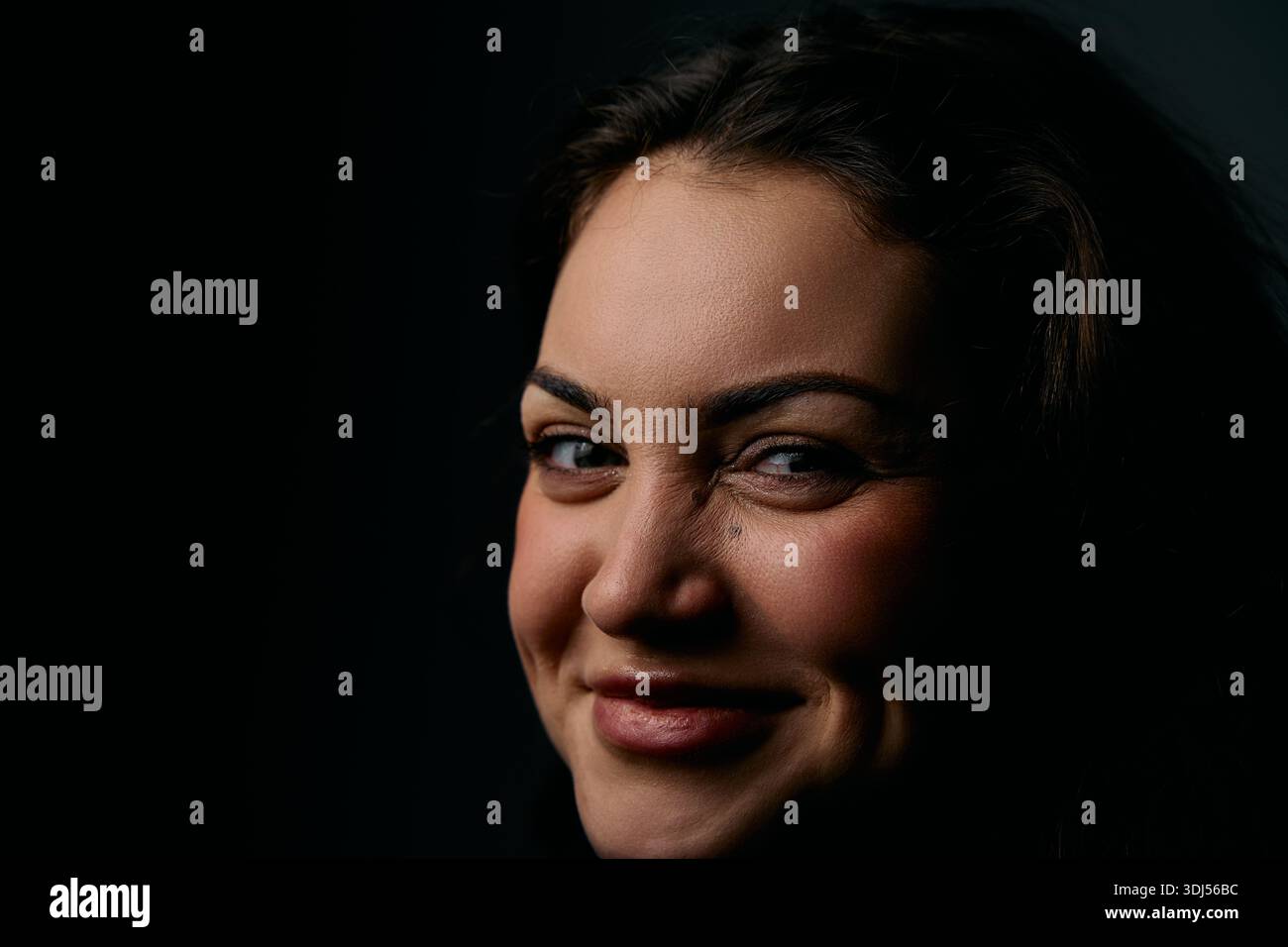 Bright Smile Portrait Of A Woman In Studio Lighting Warm, Confident Headshot Stock Photo