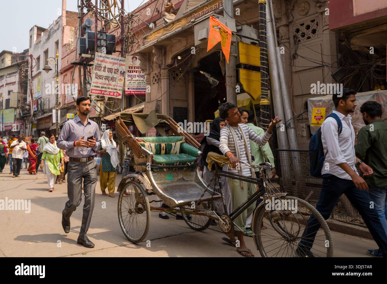 Varanasi Rickshaws Varanasi, India - March 18, 2024: A rickshaw puller stands beside his ...