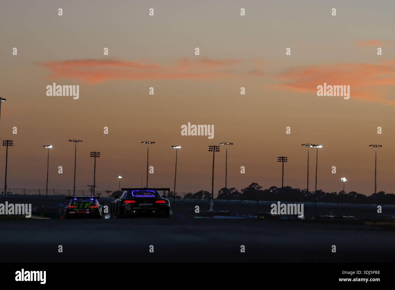 DAYTONA BEACH, FL - JANUARY 24: Cars race as the sun sets during the ...