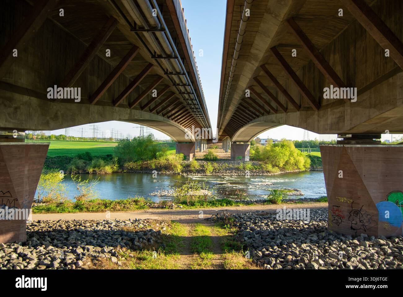 Bridge Through View A view of two large bridges spanning over a river, with greenery and ...