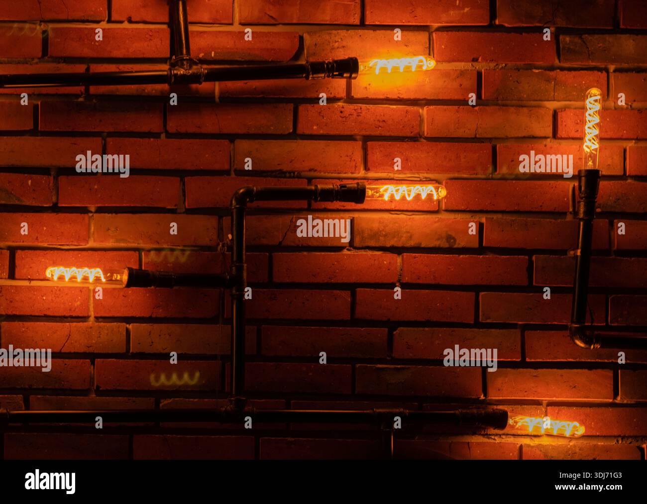 Bulbs illuminating brick wall in a restaurant. Stock Photo