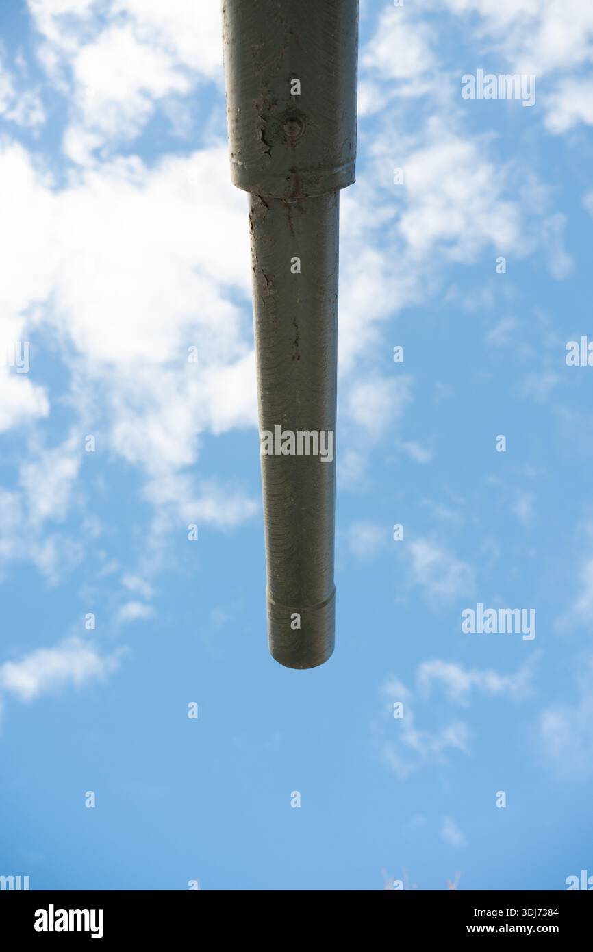 Bottom view of a tank barrel, highlighting the massive metal barrel and mounting. Emphasizes industrial strength and military machinery. Stock Photo
