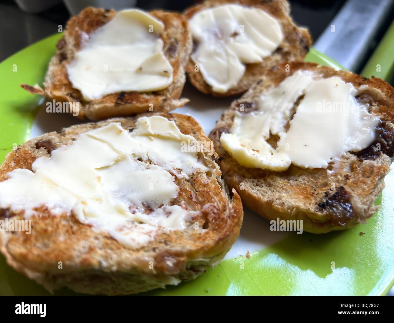 Toasted hot cross buns on a plate topped with butter - Smartphone Captured Stock Image