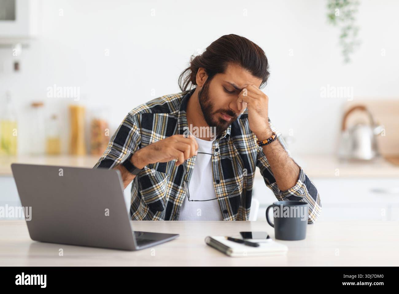 Tired middle-eastern man freelancer having difficulties at job Stock Photo