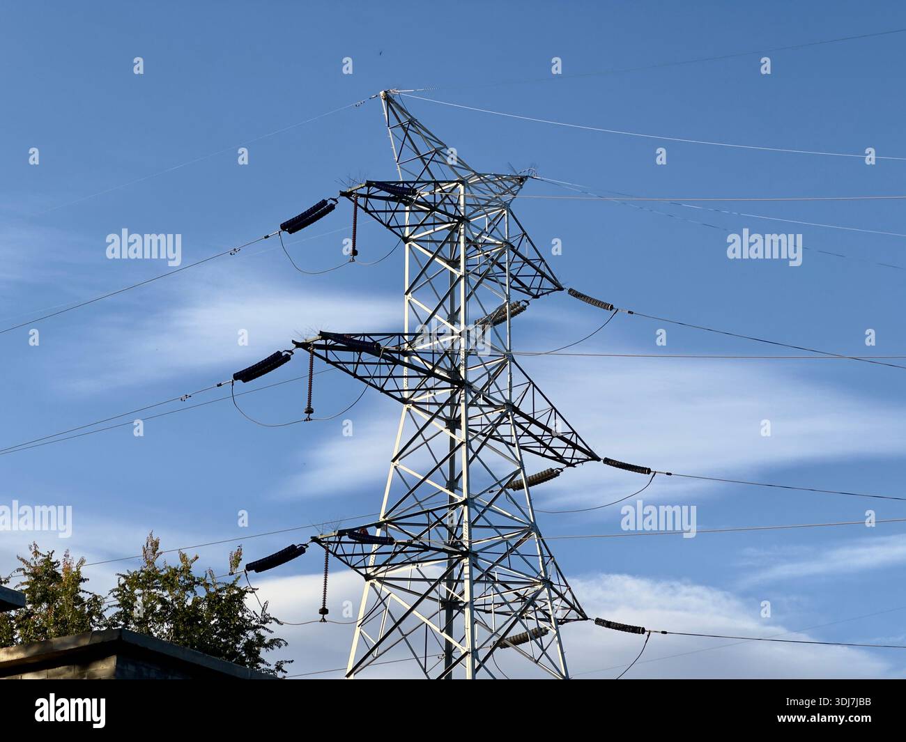Massive steel electricity pylon against a blue sky Stock Photo