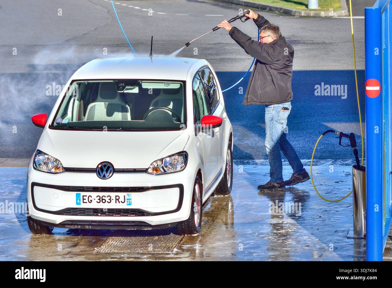 Man cleaning his Volkswagen car at a car wash facility - Loches, Indre-et-Loire (37), France. Stock Photo