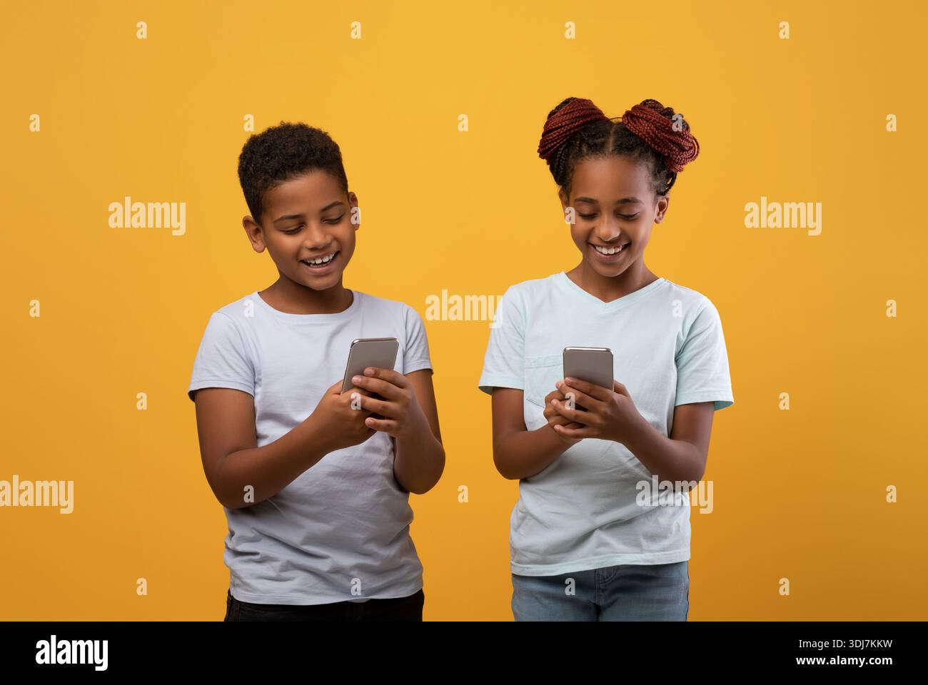 Happy black brother and sister using smartphones Stock Photo - Alamy