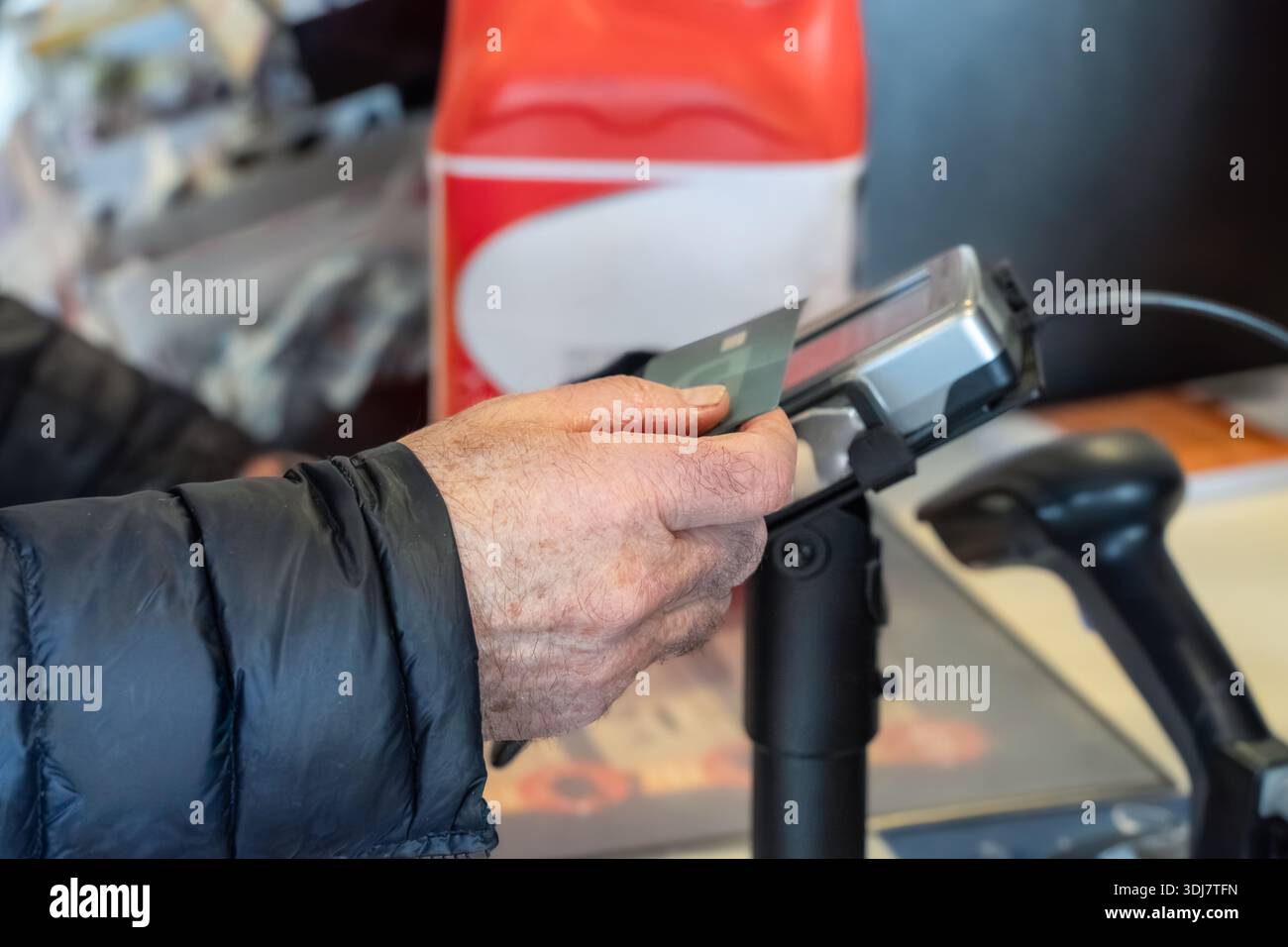 Adult male is using a credit card at a payment terminal in a retail setting, demonstrating the convenience of modern transactions and customer service Stock Photo