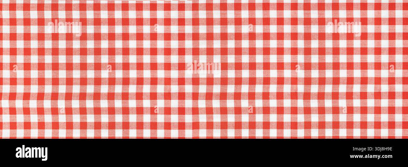 Red and white gingham fabric showing a classic checkered pattern and textile texture Stock Photo