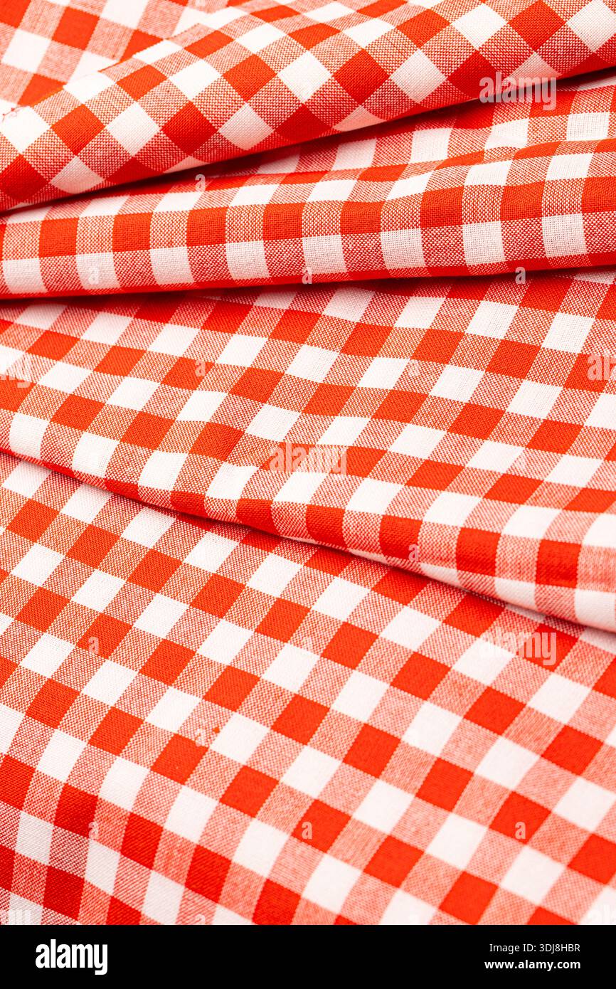 Red and white checkered gingham pattern fabric creating a textile background Stock Photo