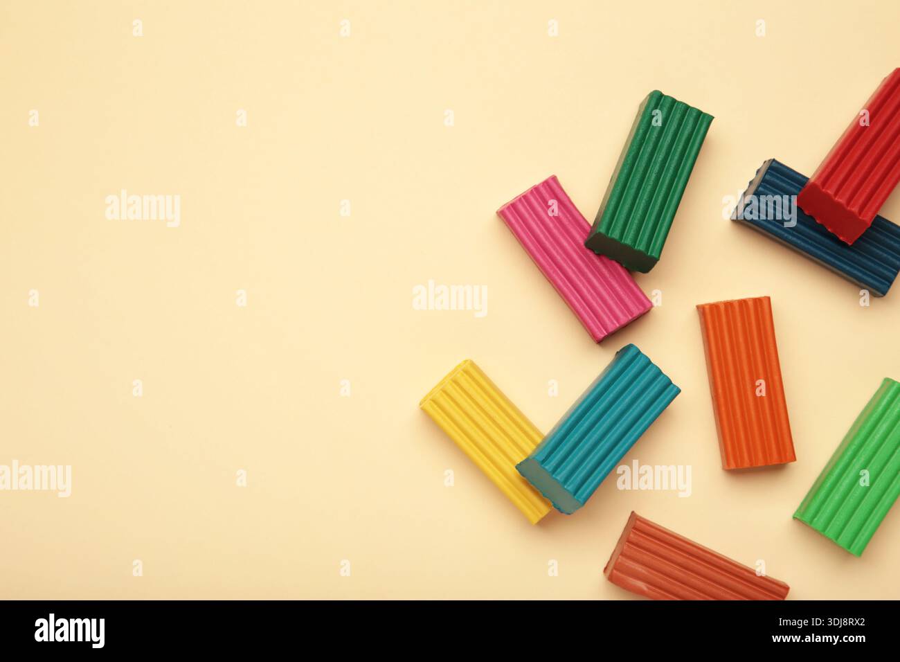 Multi-colored plasticine bricks on beige background. Childrens plasticine close-up. Stock Photo