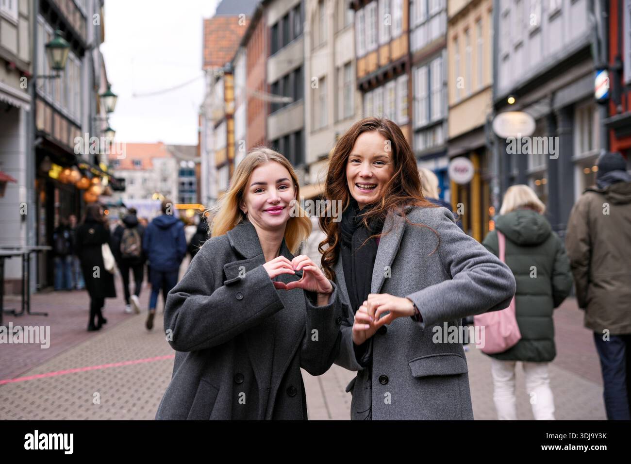 Two happy women making heart shape gesture Stock Photo