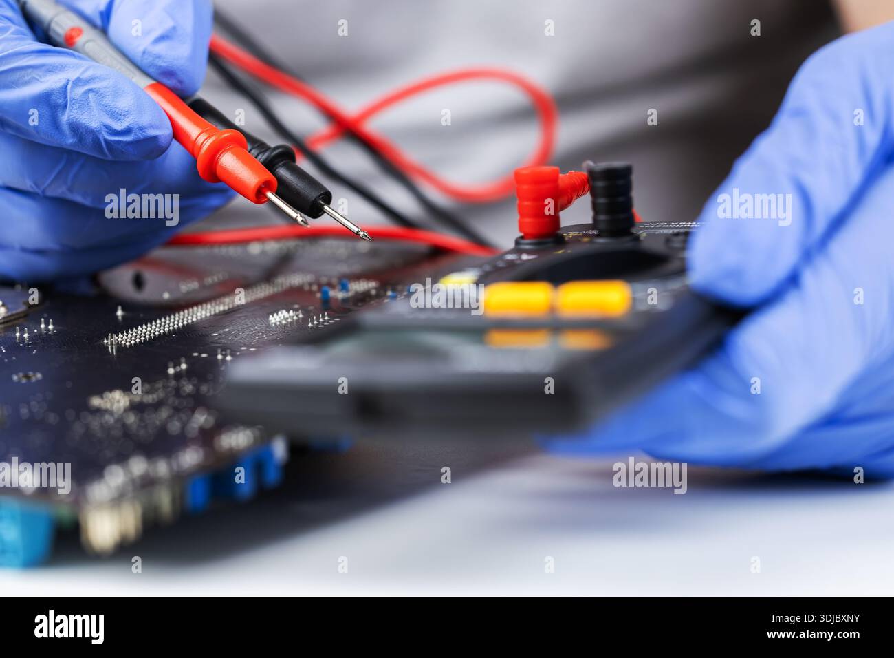 Technician under fixed and repairing computer mainboard process by used multimeter AC Voltage for analysis on computer mainboard is electronic compone Stock Photo