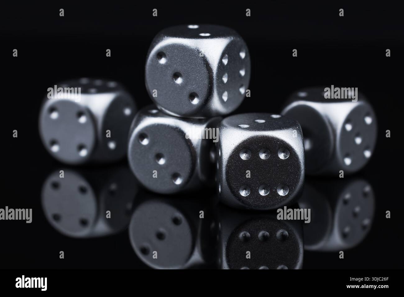 five silver dice view from above on black background. Stock Photo