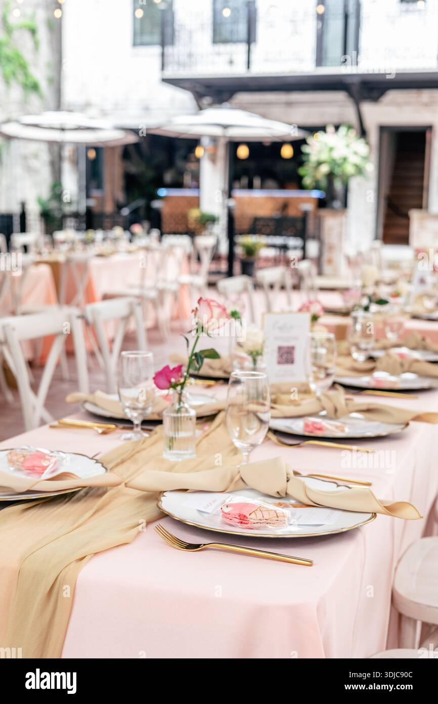 Elegant outdoor event table setup with pastel linens and floral decor Stock Photo