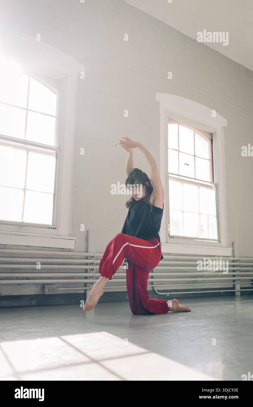 Female dancer performing contemporary movement in studio Stock Photo