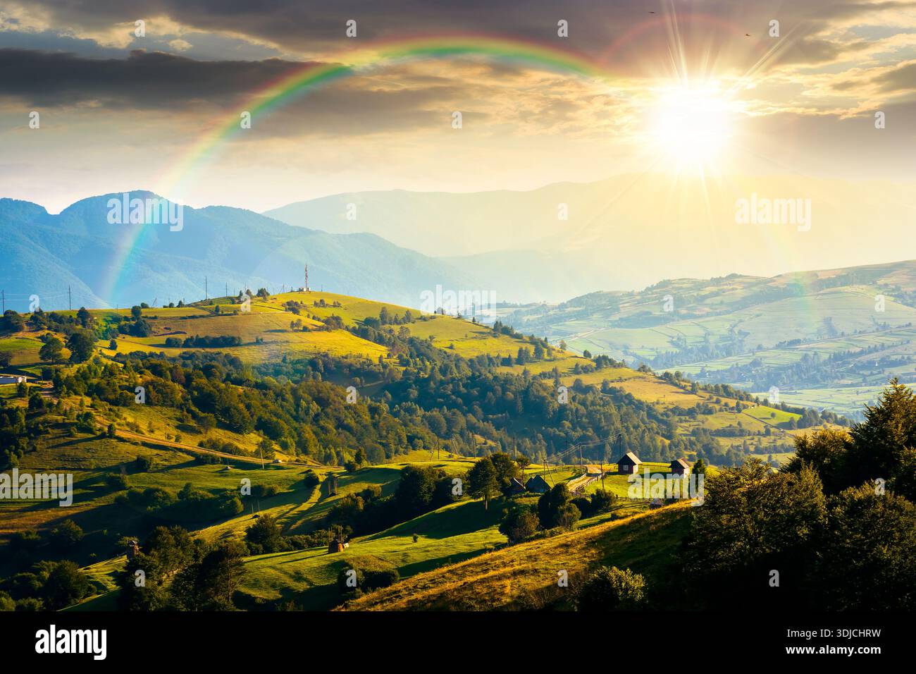 mountainous countryside landscape with rolling hills on summer sunset. rural area in evening light. beautiful view of place with green grassy pastures Stock Photo