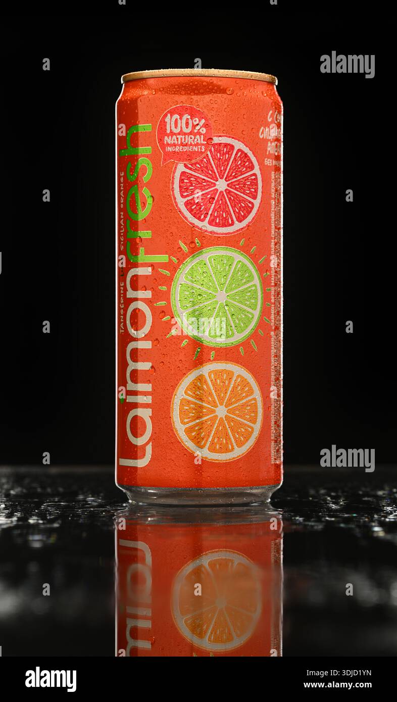 A can of laimon fresh with three oranges on it. The can is sitting on a table with a dark background Stock Photo