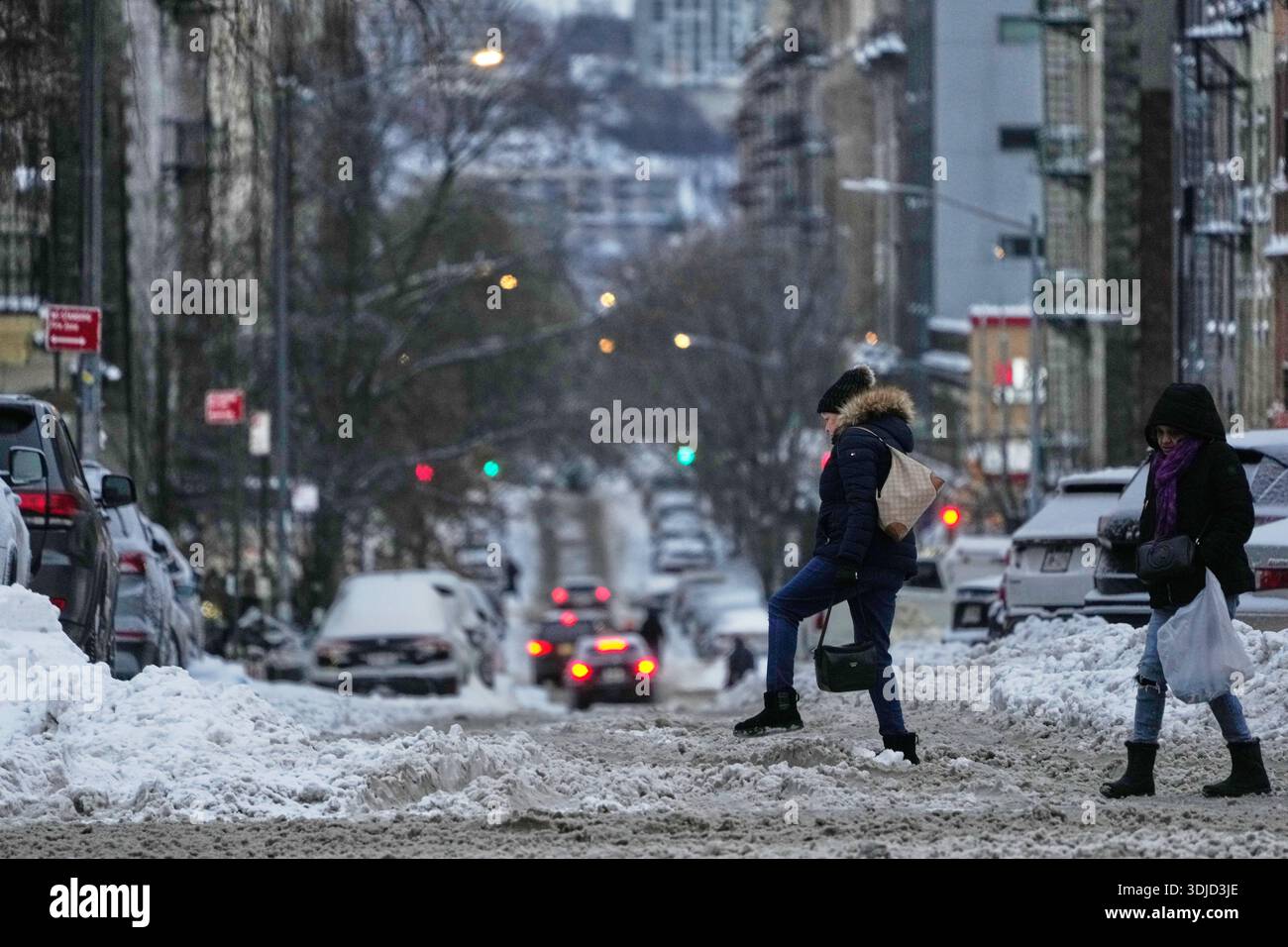 Pedestrians walk across a messy intersection in New York, Monday, Jan ...
