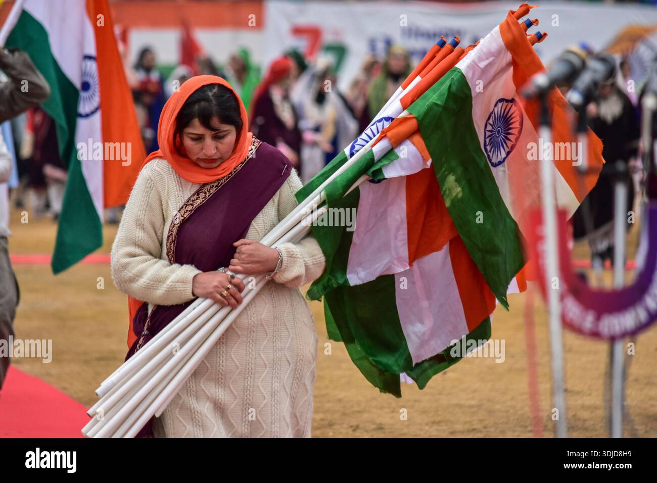 Srinagar, India. 26th Jan, 2026. A woman holds Indian national flags at ...