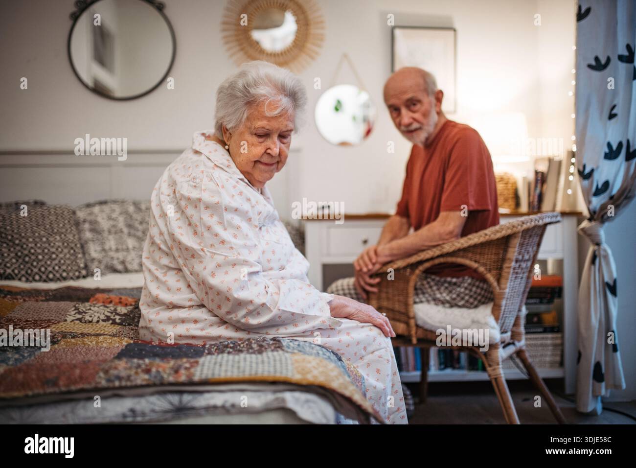 Elderly spouses sharing quiet moment before sleep. Stock Photo
