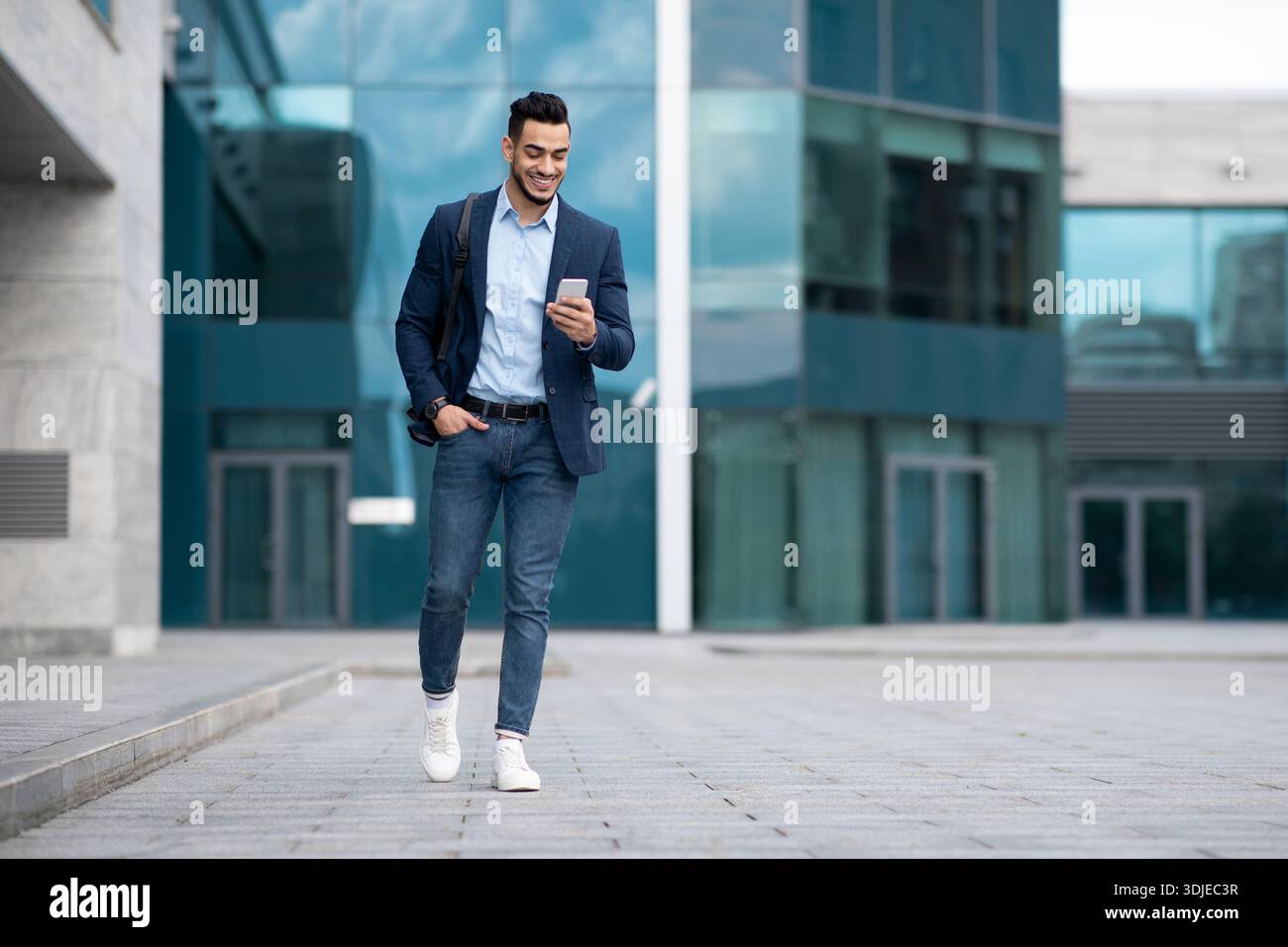 Confident arabic guy programmer with backpack walking by street Stock Photo
