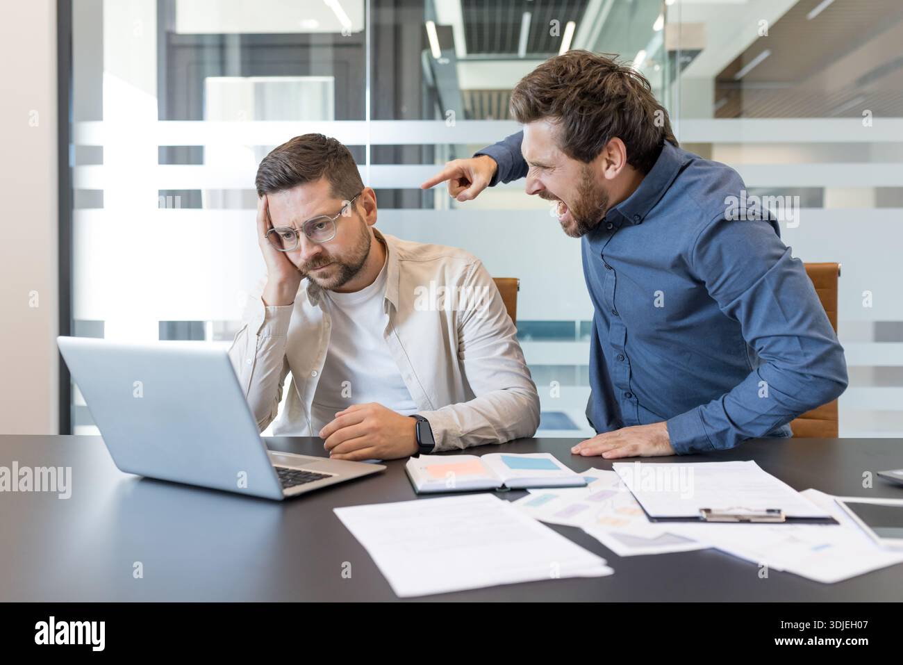 Aggressive executive is shouting and pointing at a frustrated male ...