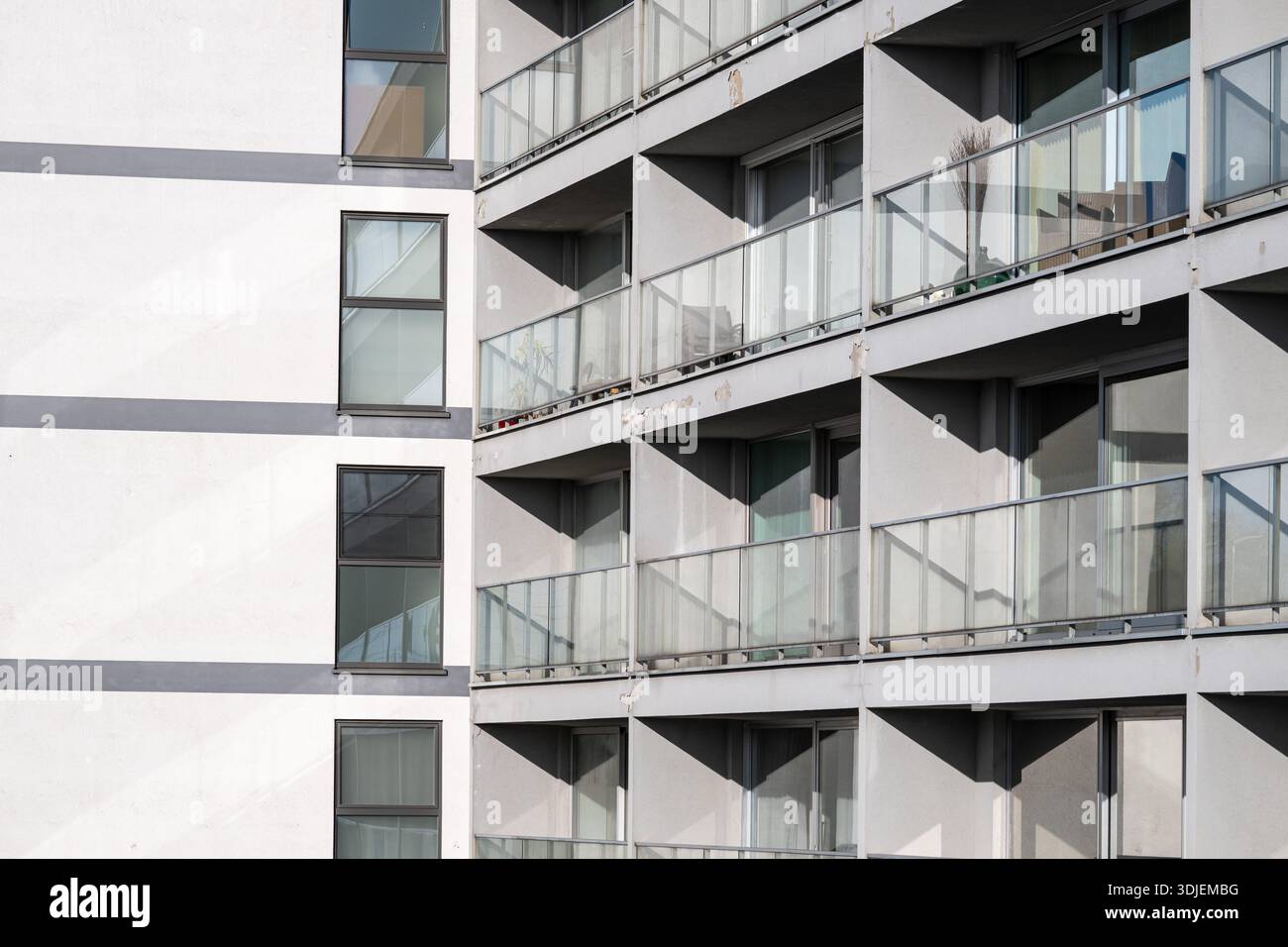 Modern high-rise apartment building with glass balconies and sleek ...