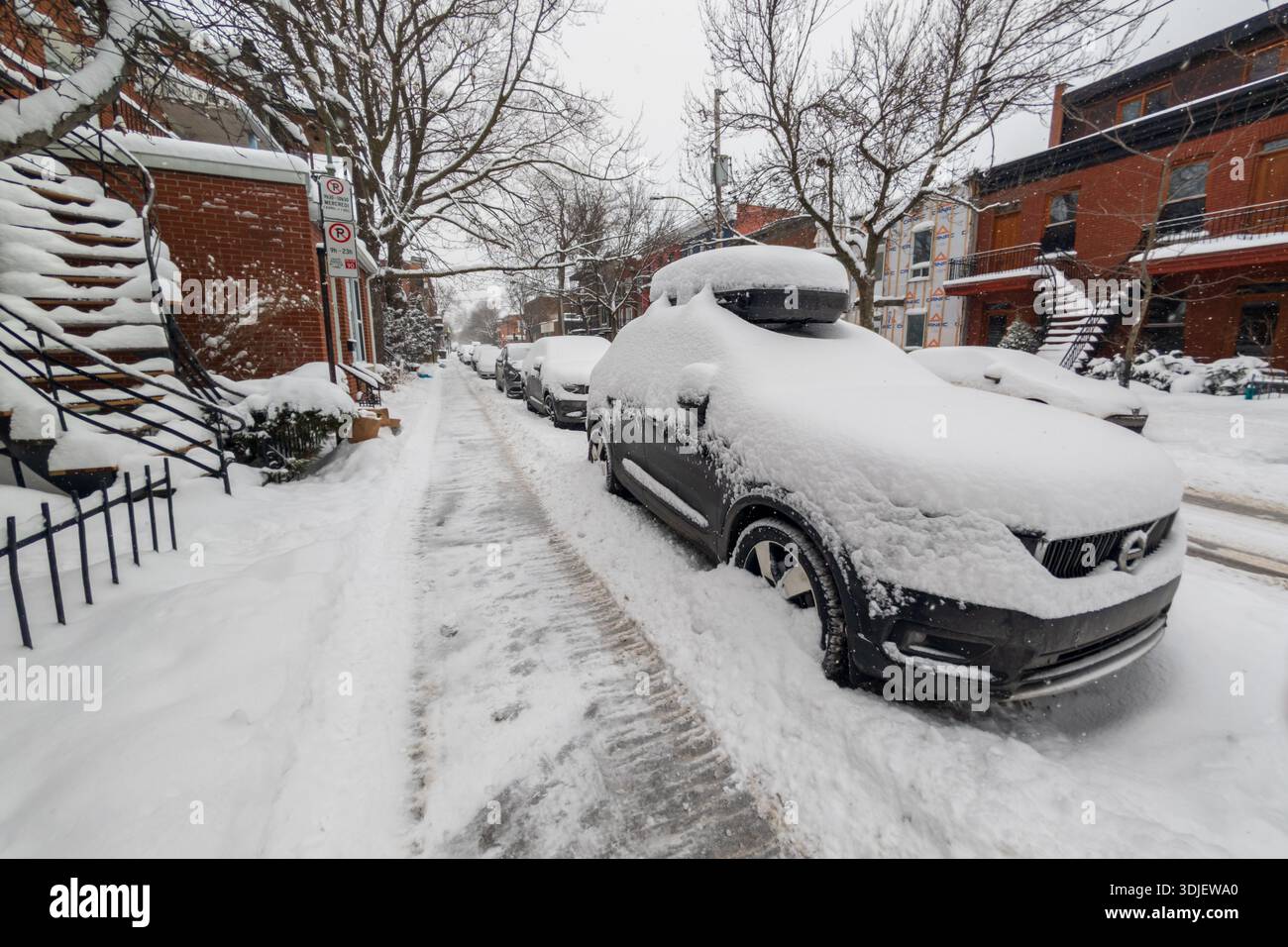 Montreal, CA - 26 January 2026: Cars parked on a snow covered residential street in Plateau Mont Royal - Smartphone Captured Stock Image