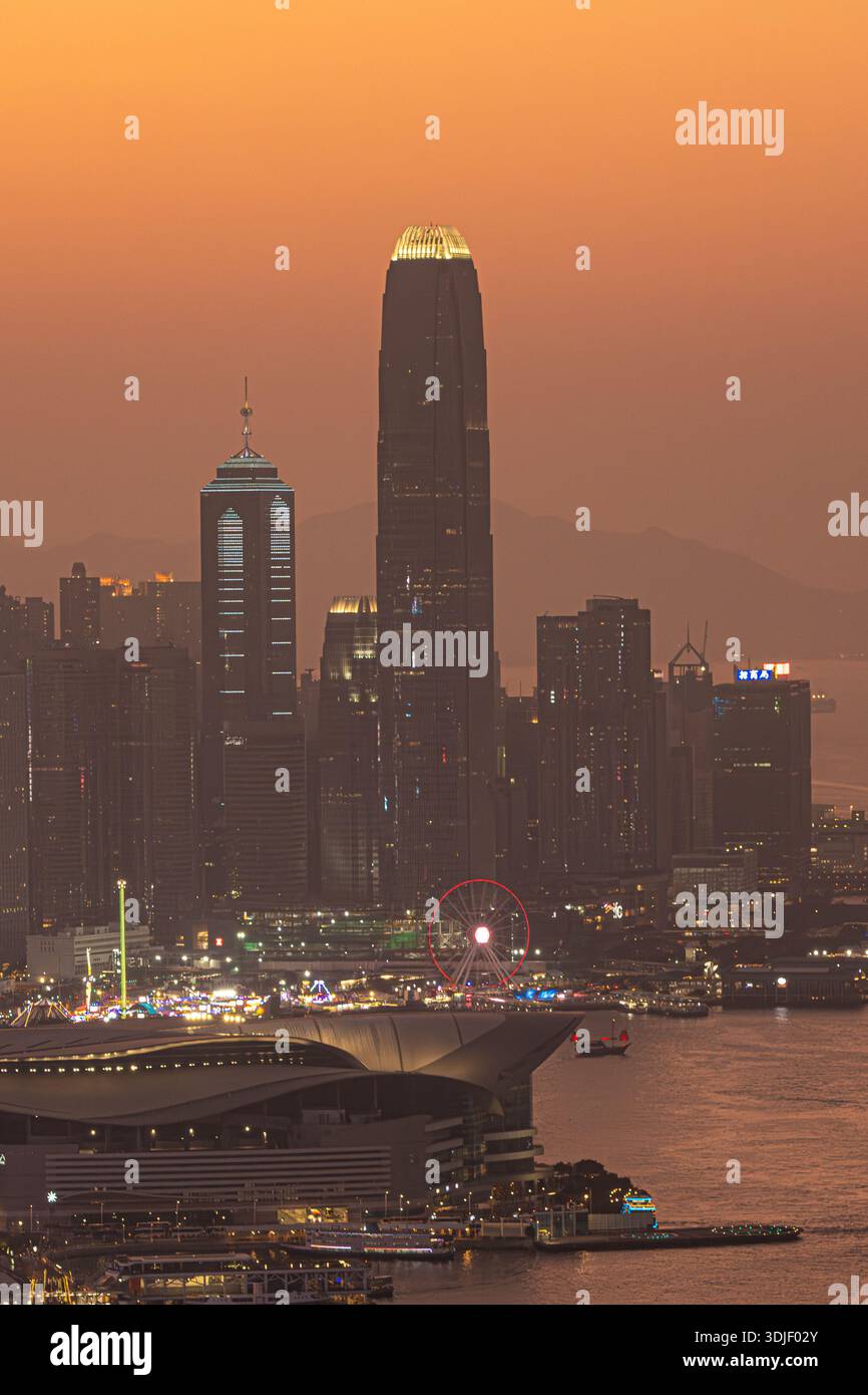 Elevated panoramic view of the Hong Kong skyline and Victoria Harbour at sunset. Stock Photo