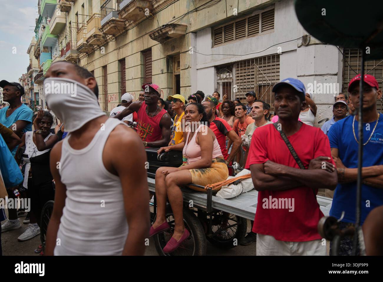 People watch from the street as firefighters extinguish a fire in an ...