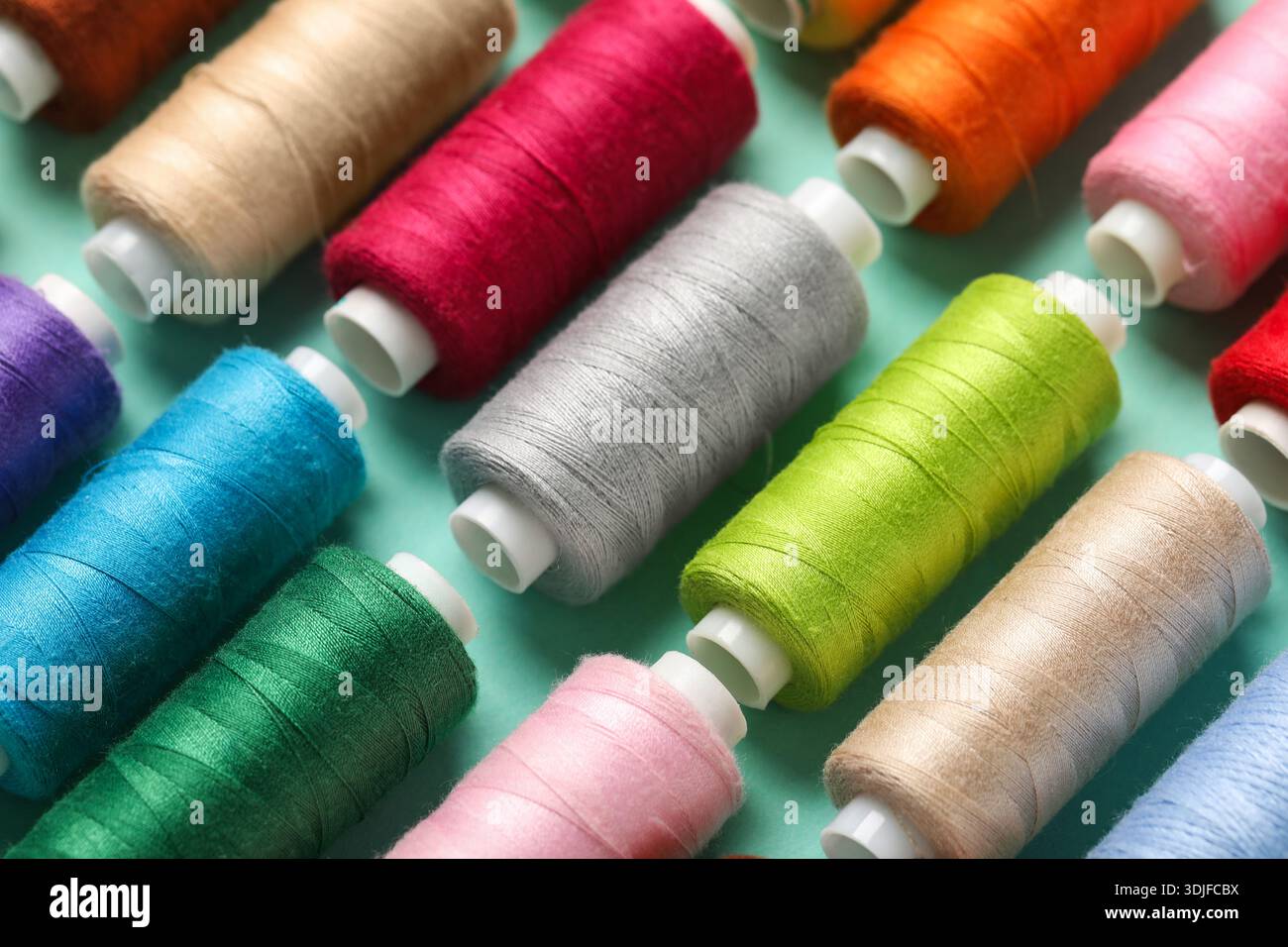 Set of different thread spools on mint background, closeup Stock Photo