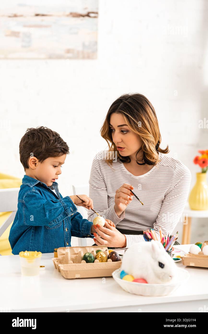 Mother and child colouring Easter eggs Stock Photo
