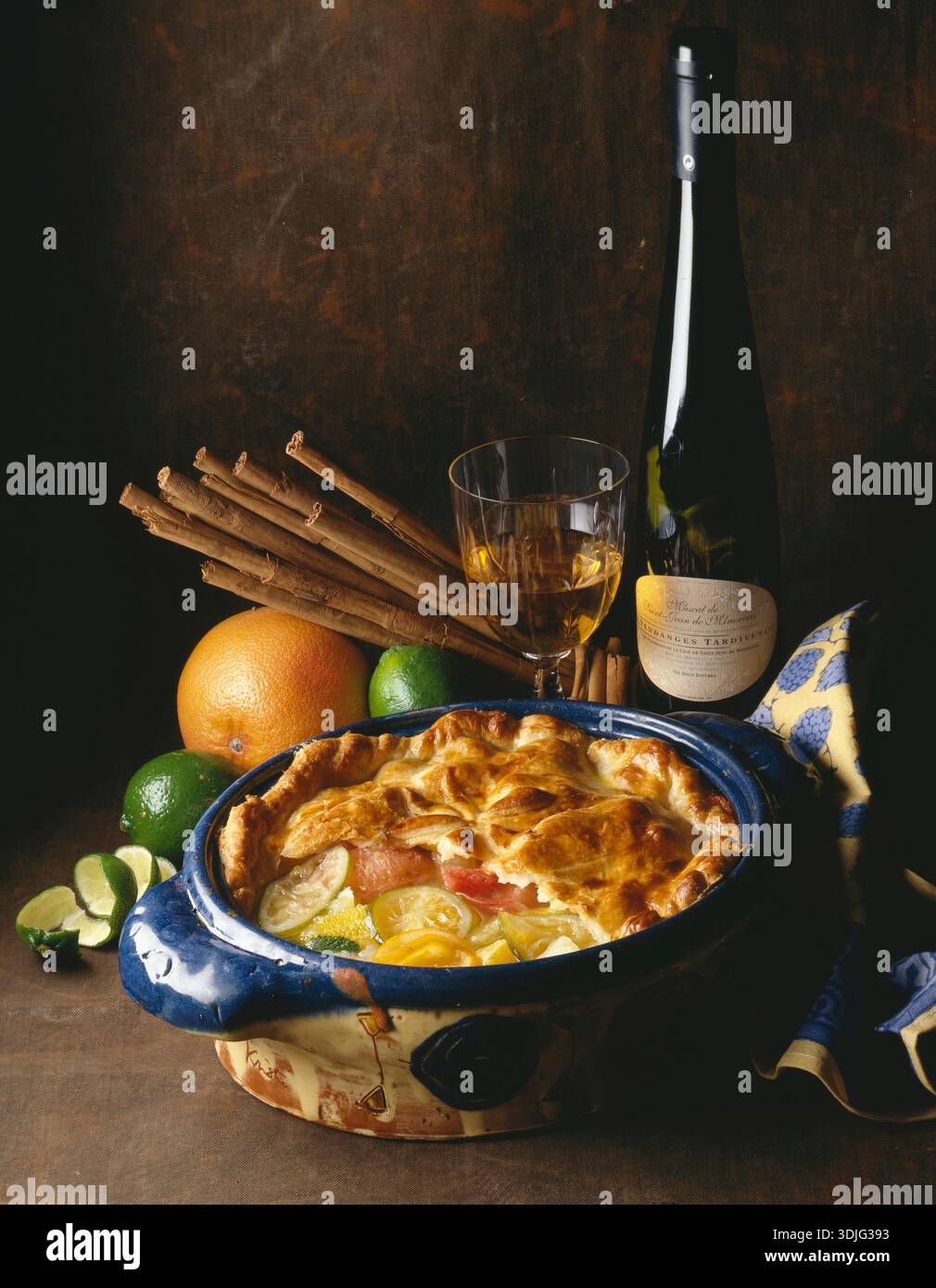 Pie with citrus fruits and a bottle of muscatel wine Stock Photo