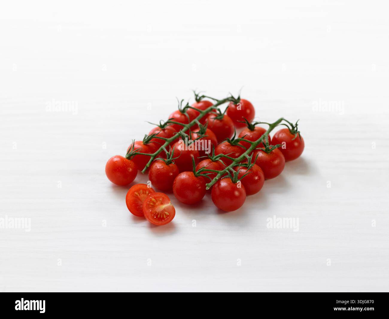 Cherry tomatoes on branches on a white background Stock Photo