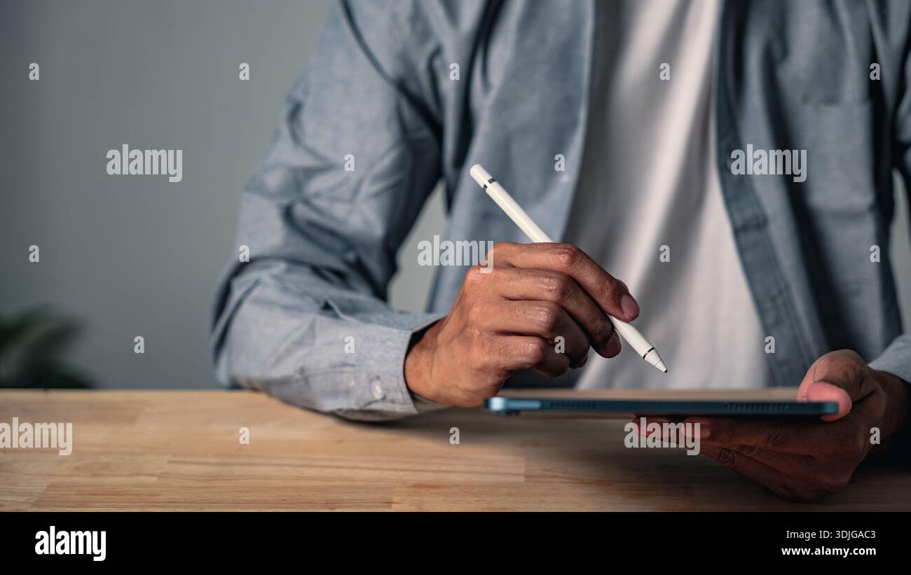 A man using a hand gesture to sign a document holds a professional business pose, a confident modern worker striking a second pose to show digital wor Stock Photo