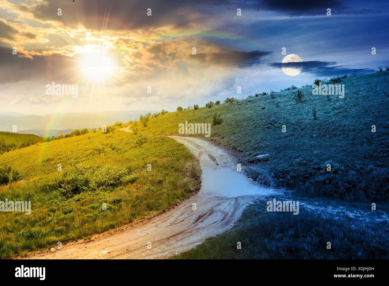 country dirt road through mountains. day and night time change concept. scenic view of green rolling hills under sky with clouds with sun and moon at Stock Photo