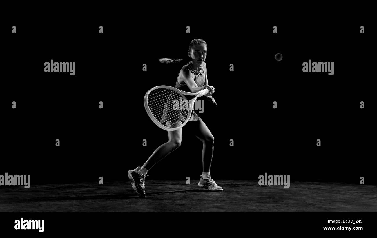 Black and white female tennis player hitting backhand shot Stock Photo ...